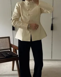 Detail of beige Chinese style blazer with traditional frog buttons and stand collar