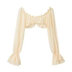 Macro detail view showing the delicate ruffles and texture of cream off-shoulder long-sleeve top