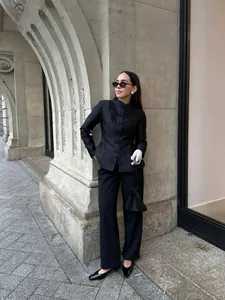 Model wearing a black modern Chinese-style frog button blazer in a street setting
