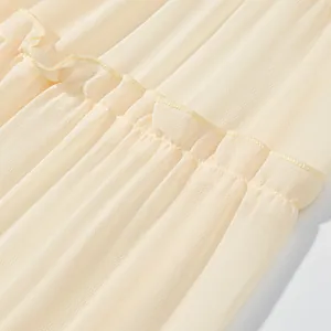 Detail shot of pleated cream chiffon fabric with elasticated smocking on tiered skirt