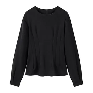 Detailed view of black long-sleeved top with waist-slimming pleats and round neckline.