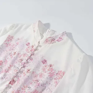 Primer plano de un elegante vestido con estampado floral rosa y cuello mandarín.