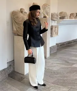 Full-body shot of a chic black blazer with stand collar and traditional frog closures