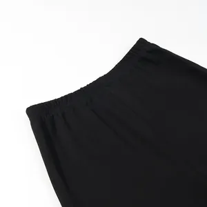 Primo piano dettagliato della fascia elastica in vita dei pantaloni a zampa neri.