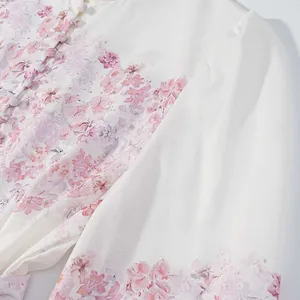 Primer plano del estampado floral rosa y textura de tela en vestido blanco largo