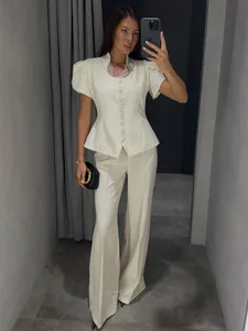 Full view of elegant white short sleeve button-up peplum top and wide leg trousers set