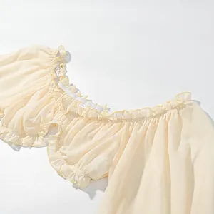 Detail view of cream-colored off-shoulder ruffled blouse showing delicate texture