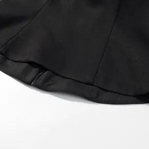 Close-up detail of the hemline and back zipper on a black sexy cropped halter neck vest.