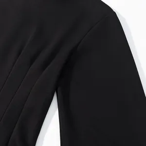 Close-up detail of black long-sleeved garment showing shoulder seam and fabric texture