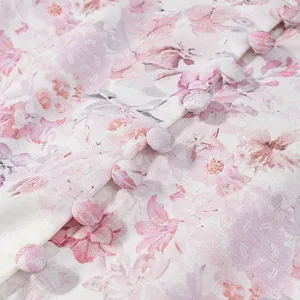 Detalle de vestido floral rosa con botones forrados en tela y un estampado suave.