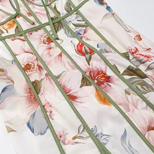 Detailansicht eines französischen Vintage-Blumenkleides mit grünen Zierstreifen.
