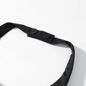 Close-up view of the adjustable two-button neck strap closure on this black halter top