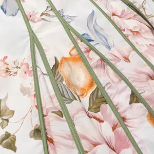 Nahaufnahme von Blumenprint und grünen Paspeln an einem sommerlichen Retro-Kleid