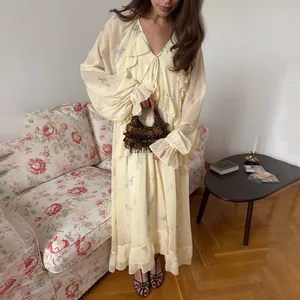 Vista detallada de un elegante vestido de malla amarilla con volantes y flores