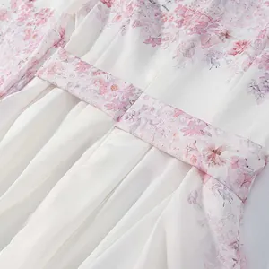 Primer plano de delicados motivos florales rosas en acuarela en un vestido blanco