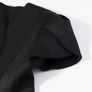 Vista dettagliata del design della manica a sbuffo nera a strati su questo top elegante