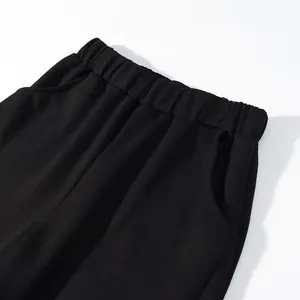 Detailed view of the comfortable elastic waistband and side pockets on black wide-leg trousers