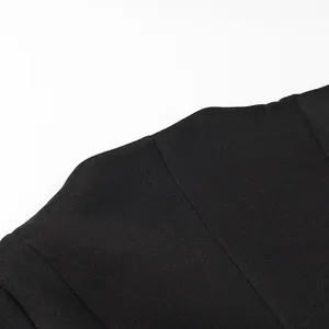 Dettaglio ravvicinato della spalla a sbuffo strutturata di un top nero alla moda