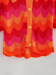 Détail d'un pull en crochet aux couleurs vives avec motif zigzag et boutons jaunes