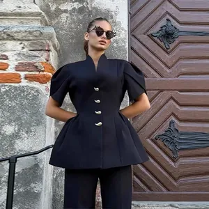 Elegante completo con top nero a maniche a sbuffo e pantaloni a zampa coordinati