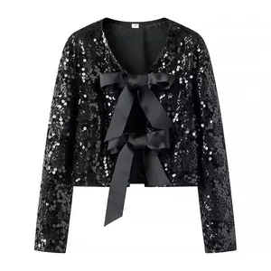 Detalle de chaqueta corta de lentejuelas negras con elegantes lazos de satén en la parte frontal
