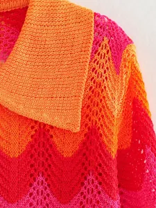 Gros plan détaillé du col polo en maille ajourée à chevrons orange et rose vif