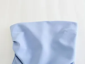 Détail en gros plan montrant le tissu et les plis d'un bustier bleu clair sans bretelles