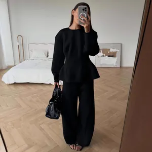 Full-length mirror selfie of a black long-sleeve peplum top and wide-leg pants