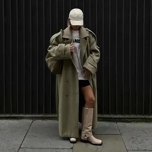 Street style view of a long olive green woolen coat with large lapels and single-breasted design.