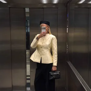 Elegant cream short blazer jacket featuring Chinese frog buttons and a minimalist stand collar