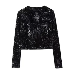 Detalle de una chaqueta corta de lentejuelas negras con mangas largas y acabado brillante