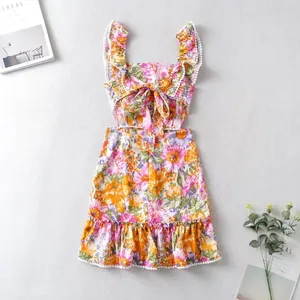 Nahaufnahme von Blumenmuster und Bommelbesatz an diesem sommerlichen Trägerkleid