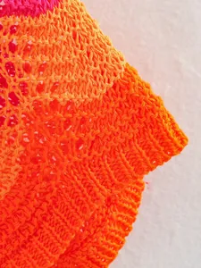 Gros plan sur le tissu en maille crochetée orange vif montrant une texture fine