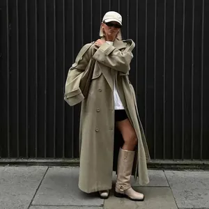 Model wearing a stylish long khaki wool trench coat with large lapels in a street setting