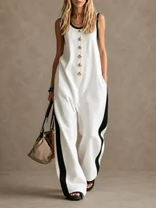 Detail view of sleeveless white jumpsuit featuring contrast side stripes and gold buttons.