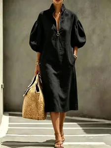 Elegant black midi dress featuring puff sleeves and a chic metallic ring zipper detail.
