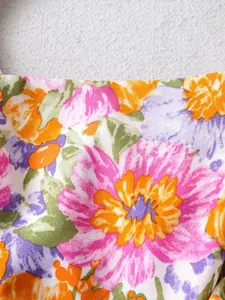 Detailansicht des lebhaften Blumenmusters auf einem sommerlichen Strandkleid