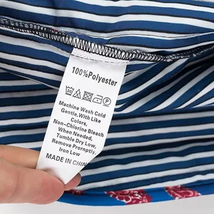 Close-up of care label showing 100% polyester on striped fabric vest.