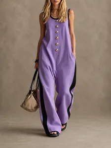 Detail view of purple sleeveless jumpsuit with creative golden buttons and side stripes.