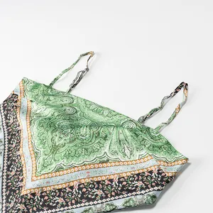 Close-up detail of green paisley print camisole with thin straps and elegant scarf hem