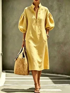 Detailed view of yellow linen-textured midi dress with puff sleeves and front zipper