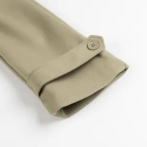 Detail of a khaki woolen coat sleeve featuring a buttoned cuff strap on a white background.