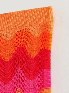 Gros plan détaillé sur la texture en maille crochetée en zigzag orange et rouge vif