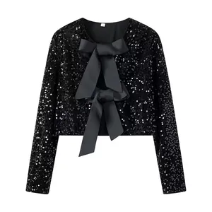 Close-up detail of a sparkly black sequined jacket with large satin bow accents.
