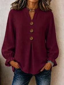Detailed view of women's burgundy V-neck blouse with decorative wooden buttons and ruffled cuffs