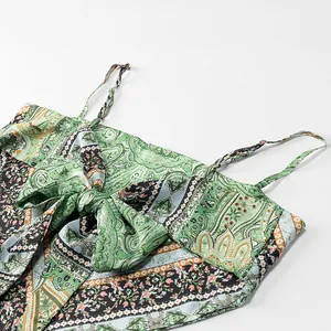 Close-up detail of a green paisley print camisole featuring a prominent bow design