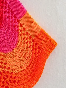 Gros plan sur le tissu en maille crochetée rose et orange avec motif à mailles