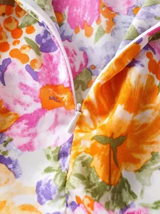 Nahaufnahme des verdeckten Reißverschlusses am farbenfrohen Blumenkleid-Stoff