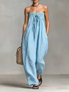 Dettaglio della tuta strapless azzurra con corpino arricciato e fiocco frontale