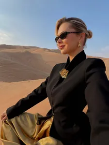 Chic black single-breasted blazer with gold skirt shown in a stylish desert shoot